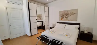 a bedroom with a white bed and a mirror at Di Fresco Apartments Luxury Suites in Palermo