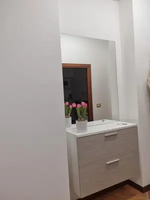 a bathroom with a sink with flowers in a mirror at Giardino Moreno in Palermo