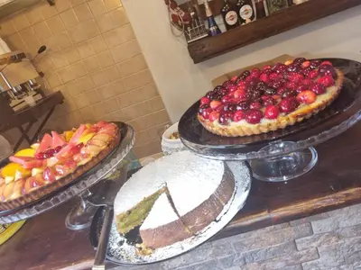 three pies with fruit on them sitting on a counter at Giardino Moreno in Palermo