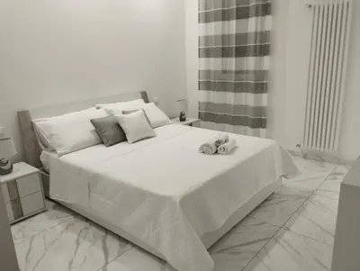 a white bedroom with a bed with two shoes on it at casa nike in Palermo