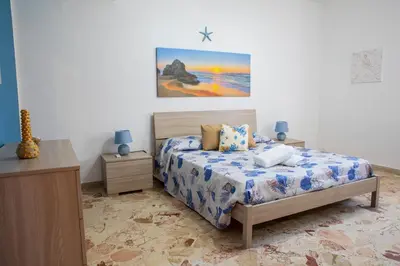 a bedroom with a bed and a painting on the wall at Beddamuri home in Carini