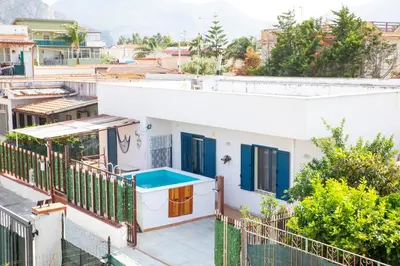 a white house with a blue pool on a balcony at Beddamuri home in Carini