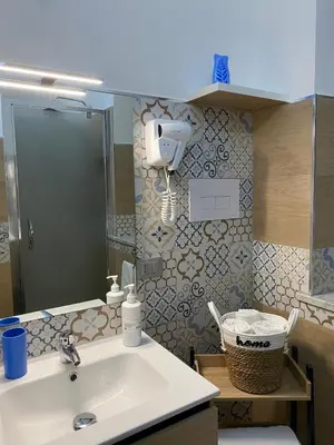 a bathroom with a sink and a hair dryer on the wall at La Dimora di David in Bagheria