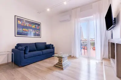 a living room with a blue couch and a tv at Eye on the Politeama - L'occhio sul Politeama in Palermo