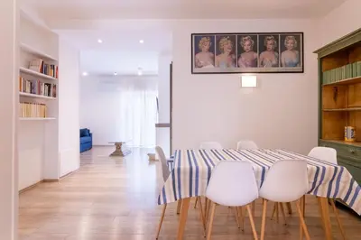 a dining room with a table and white chairs at Eye on the Politeama - L'occhio sul Politeama in Palermo