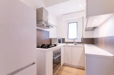 a white kitchen with a stove and a sink at Eye on the Politeama - L'occhio sul Politeama in Palermo