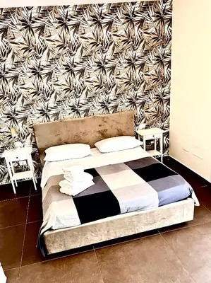 a bed with a black and white comforter in a room at TorreNormanna Prestige House near Cefalù in Mandra Capreria