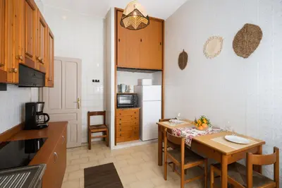 a kitchen with a table with chairs and a refrigerator at - Palermo - Sferracavallo sul mare in Palermo
