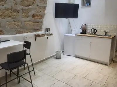 a kitchen with white cabinets and a table and chairs at La casetta nel vicolo in Palermo
