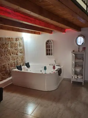 a bath tub in a room with a stone wall at La casetta nel vicolo in Palermo