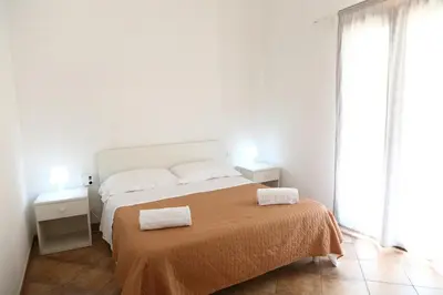 a white bedroom with a bed with two towels on it at verdemare in relax in Cefalù