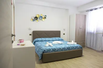 a bedroom with a bed with a blue comforter at B&B Piano di Sopra in San Vito lo Capo