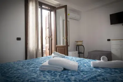 a bedroom with a blue bed with towels on it at B&B Piano di Sopra in San Vito lo Capo