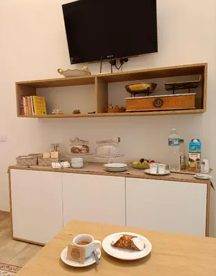 a table with a plate of food and a tv at Butiko in Castelluzzo