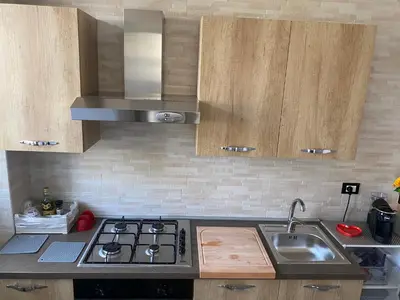 a kitchen with a sink and a stove and cabinets at Casa Narciso - Mondello in Mondello