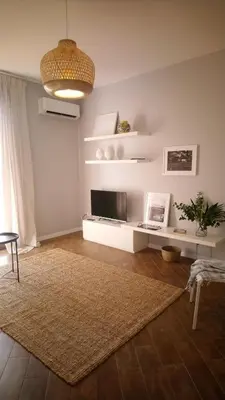 a living room with a television and a rug at Loft 407 in Cinisi