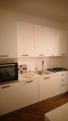 a white kitchen with a sink and a microwave at Loft 407 in Cinisi