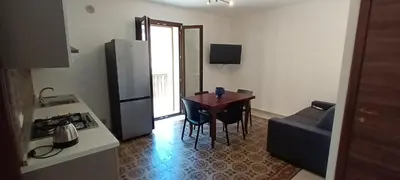 a small kitchen with a table and a refrigerator at Palazzo DS in Castellammare del Golfo