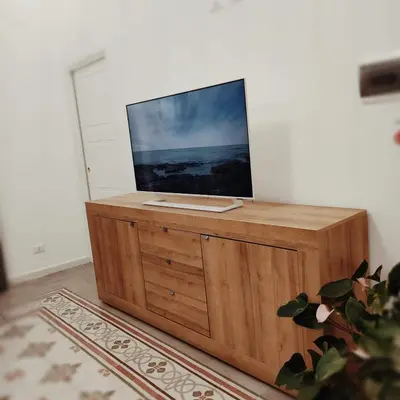 a television on top of a wooden stand in a room at Piazza Vittoria Apartment in Carini