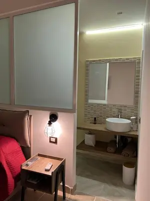 a bathroom with a bed and a sink and a table at ZA HOUSE in Palermo
