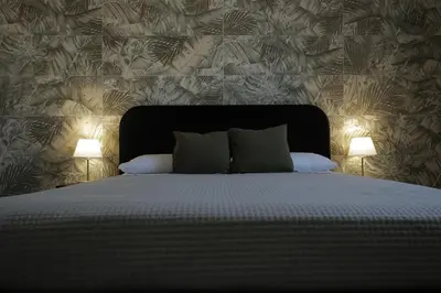 a bedroom with a large bed with two lamps at Sikelìa Bed & Breakfast in Carini