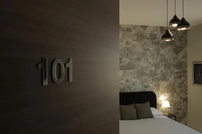 a bedroom with a bed and a wall with the number at Sikelìa Bed & Breakfast in Carini