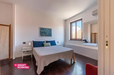 a bedroom with a bed with blue pillows and a window at Schiavuzzo Apartment with Terrace by Wonderful Italy in Palermo