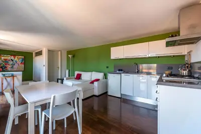 a kitchen and living room with a table and a couch at Schiavuzzo Apartment with Terrace by Wonderful Italy in Palermo