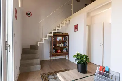 a living room with stairs and a book shelf at SHANTI HOLIDAY HOUSE in Palermo
