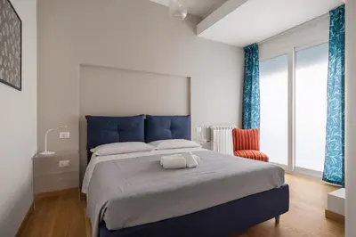 a bedroom with a blue bed and a red chair at Giusà by DomuSicily in Palermo