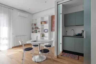 a kitchen with a table and chairs in a room at Giusà by DomuSicily in Palermo