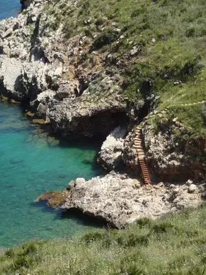 a staircase on the side of a mountain near the water at Appartamenti Cala Rossa (Antonella) in Castellammare del Golfo