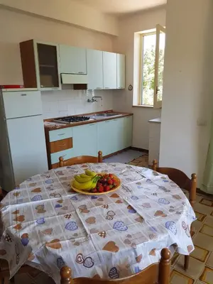 a kitchen with a table with a plate of fruit on it at Appartamenti Cala Rossa (Antonella) in Castellammare del Golfo