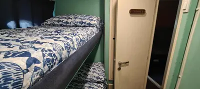 a bedroom with a bed with blue and white sheets at Panaby - House Boat in Palermo
