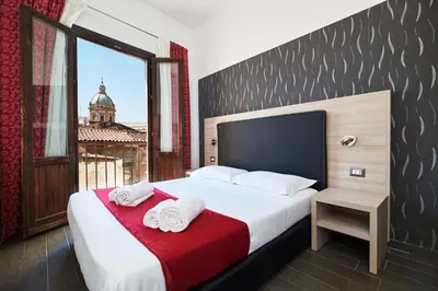 a bedroom with a large bed with towels on it at La Terrazza sul Centro in Palermo