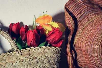 a basket of flowers sitting next to a couch at La Terrazza sul Centro in Palermo