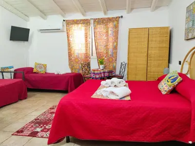 a room with two beds with red sheets and towels at B&B Sikelia in Terrasini