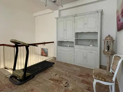 a room with a treadmill and a chair and cabinets at Dai Maestri Rubino in Vita