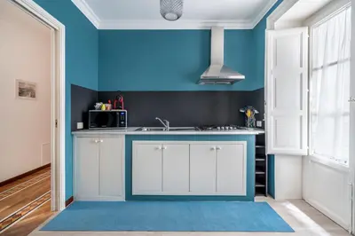 a kitchen with blue walls and white cabinets at Casa Bentivegna in Palermo