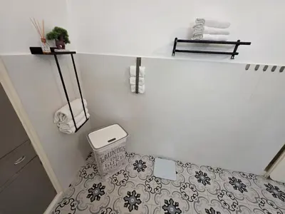 a white bathroom with a toilet and a sink at Elisir house in Palermo