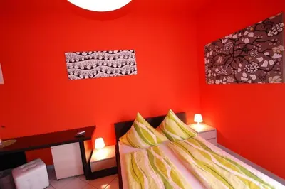 a bedroom with red walls and a bed with yellow pillows at Il Muretto in Lascari