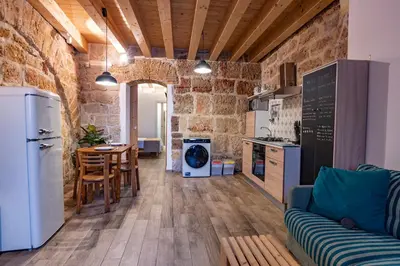 a kitchen and living room with a couch and a table at Loft Vetriera in Palermo
