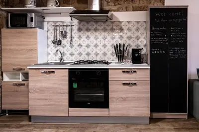 a kitchen with a stove top oven next to a wall at Loft Vetriera in Palermo