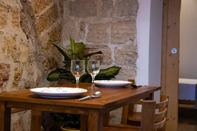 a wooden table with two glasses of wine at Loft Vetriera in Palermo