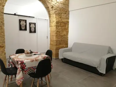 a bedroom with a bed and a table and chairs at Suites Masculu & Fimmina in Palermo