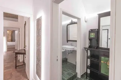 a hallway with a bathroom with a sink and a mirror at Calderai 82 suites 1 e 2 in Palermo