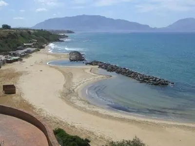a beach with rocks in the water and the ocean at Gravina in Trappeto