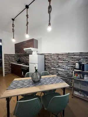 a dining room table with chairs and a vase on it at Tiny house in Palermo