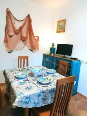 a table with bowls and plates on it with a laptop at Casa Tequi a 200mt dal mare in Terrasini
