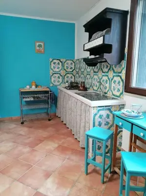 a kitchen with blue walls and a stove top oven at Casa Tequi a 200mt dal mare in Terrasini